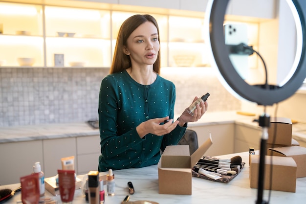 Pretty young womam demonstrating samples of new cosmetics