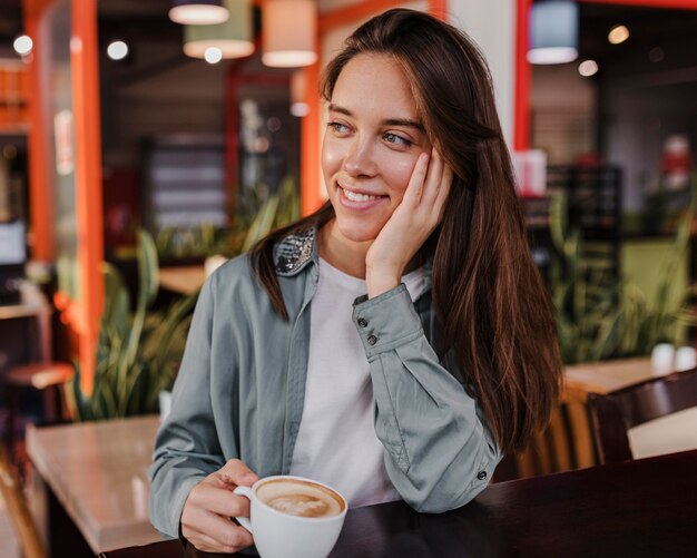 Pretty young woman enjoying a coffee cup