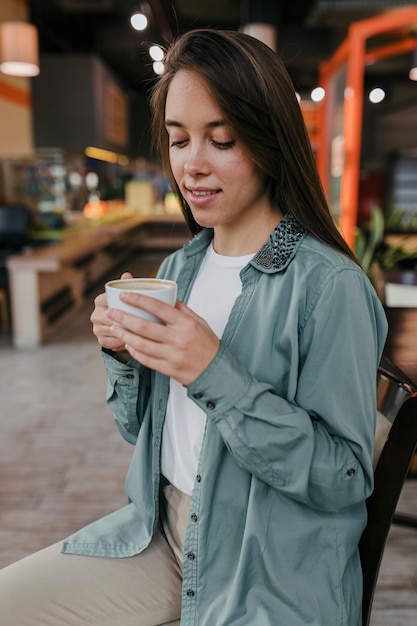 Pretty young woman enjoying a coffee cup