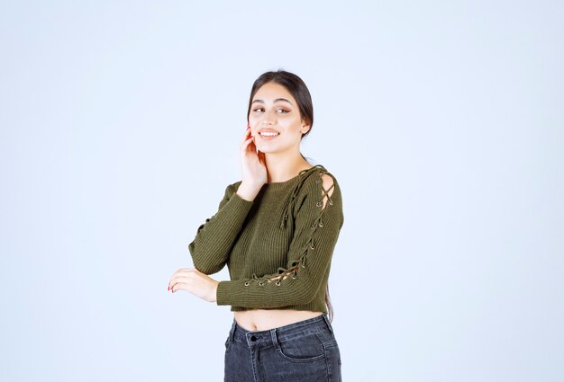 Pretty young woman feeling happy on white wall