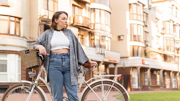 Pretty young woman posing with bike