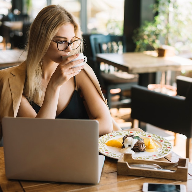 Pretty young woman sitting in caf��� drinking coffee