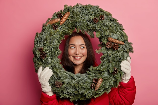 Free Photo pretty and young woman wearing christmas wreath on her head