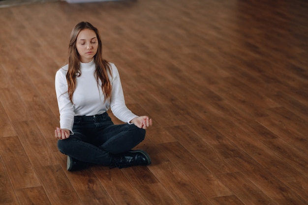 Pretty young woman in a white blouse on the floor