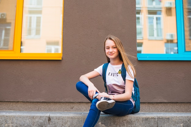 Free Photo pretty youngster with backpack posing outside