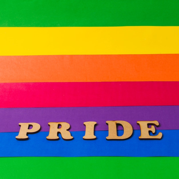 Pride wooden word on colorful LGBT flag