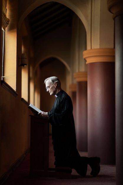 Free Photo priest praying in church