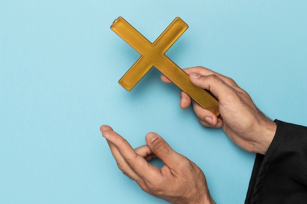 Free photo priest with cross finger and wood cross