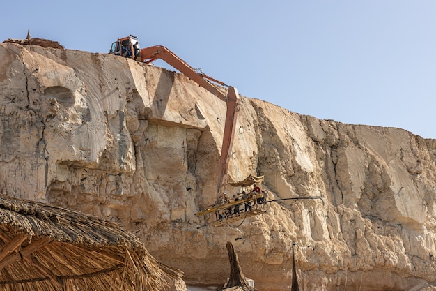 The process of extracting rocks from a cliff in Egypt.