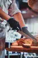 Free photo process of seeded loaf slicing at the kitchen for breakfast at posh hotel by baker.