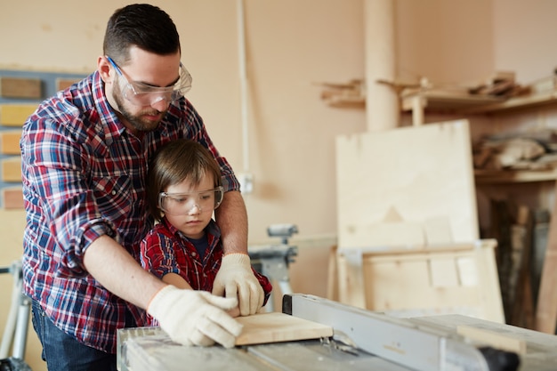 Processing workpiece, father and son working with wood