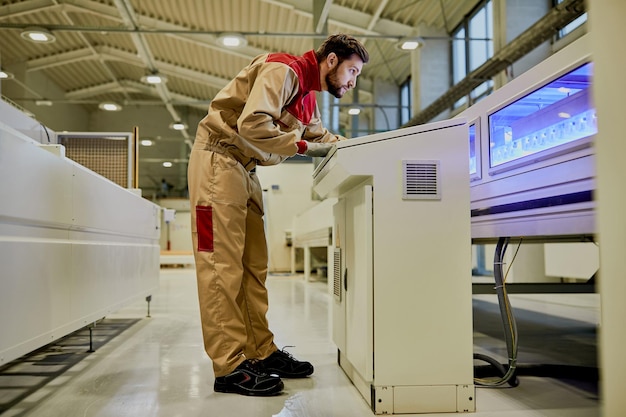 Free photo production line worker operating automated machine at woodworking industrial facility