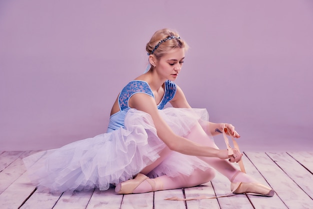 Professional ballerina putting on her ballet shoes.