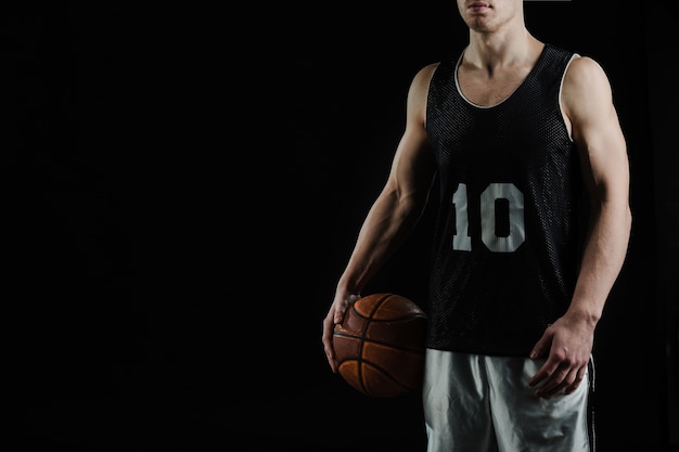 Professional basketball player holding the ball under his arm