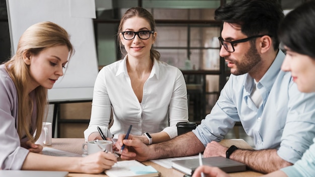 Free photo professional businesswoman with glasses during a meeting with her coworkers