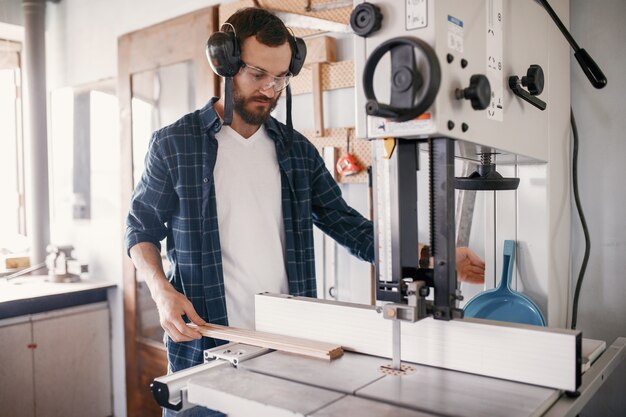 Professional carpenter working with sawing machine