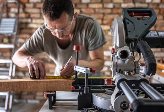 Free photo a professional carpenter works with a circular saw miter saw in a workshop.