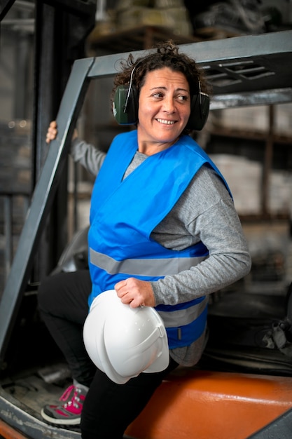 Free photo professional female driver operating forklift vehicle