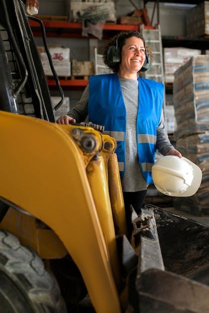 Free photo professional female driver operating forklift vehicle