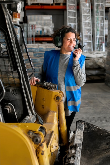 Free photo professional female driver operating forklift vehicle