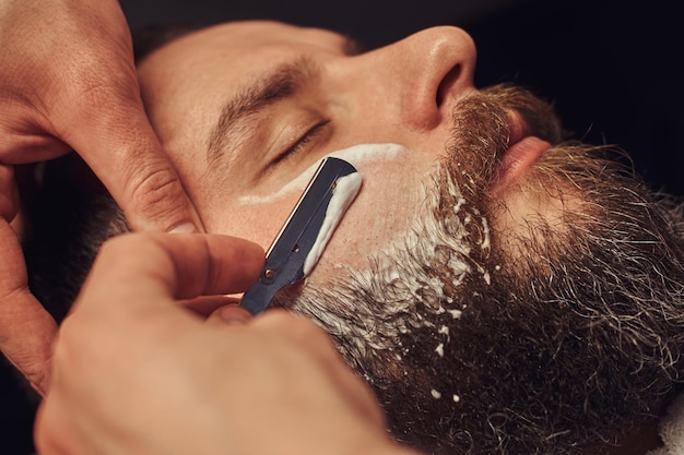 Free photo professional hairdresser modeling beard at the barbershop. close-up photo.