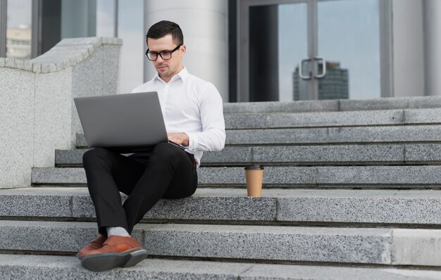 Professional looking on laptop outdoors