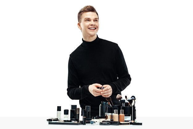 Professional makeup artist with tools isolated on white studio background. The man in female proffesion. gender equality concept