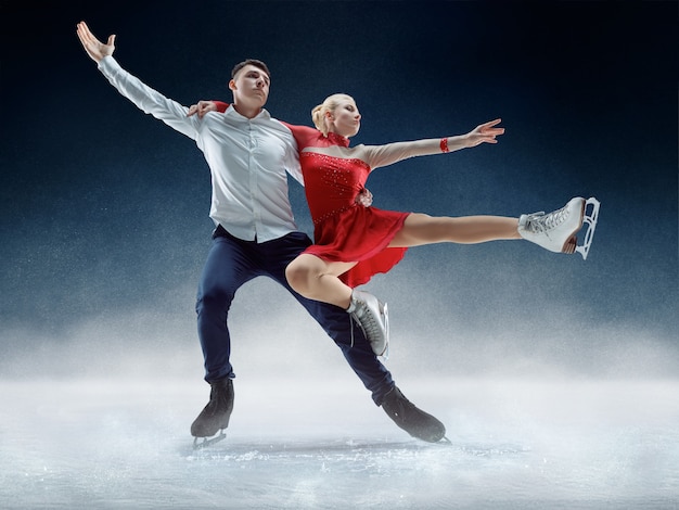 Free photo professional man and woman figure skaters performing show or competition on ice arena