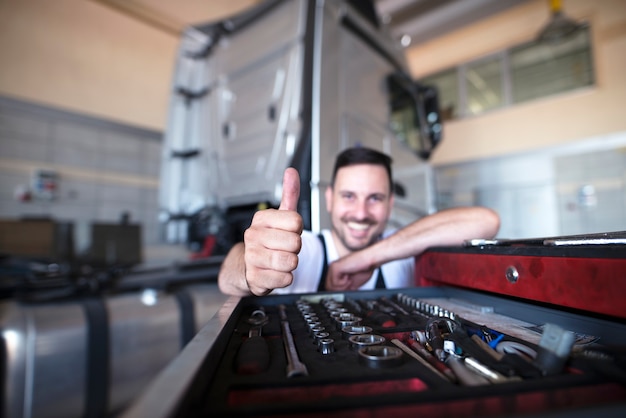 Free photo professional mechanics by the tools cart showing thumbs up