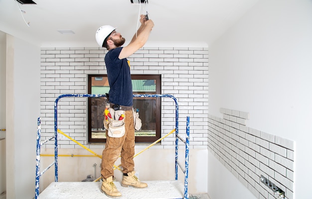 Free photo professional in overalls with tools on the background of the repair site. home renovation concept.