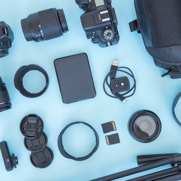 Free photo professional photographer accessories and equipments arranged on blue backdrop