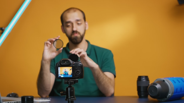 Free photo professional photographer talking about nd filters effect on image for his vlog.variable nd filter review, camera gear and equipment video. ceator influencer social media star distributing online cont