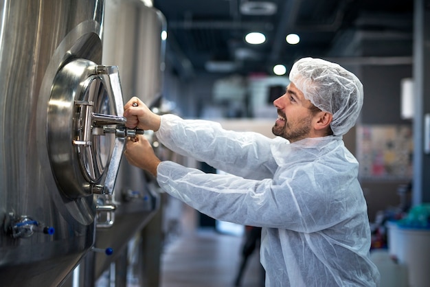 Free Photo professional technologist opening industrial tank in production plant