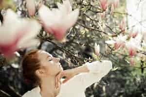 Free photo profile of pretty girl with magnolia flowers