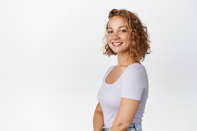 Profile shot of candid blond girl, smiling happy and looking, standing in tshirt white. Copy space