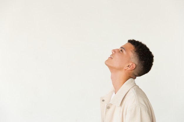 Free photo profile of smiling young man looking up