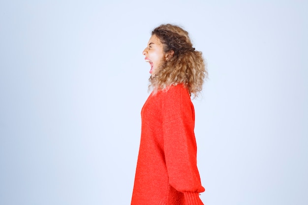 Free Photo profile view of a shouting woman in red shirt. 