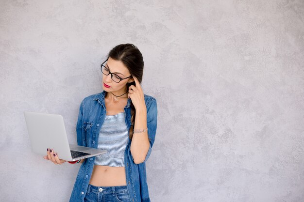 Profile view of a thinking woman with laptop