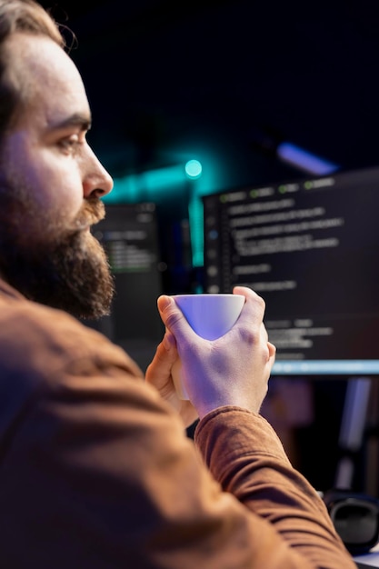 Free Photo programmer drinking cup of coffee in the morning while building firewalls