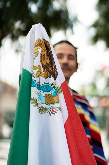 Proud man holding mexican flag front view