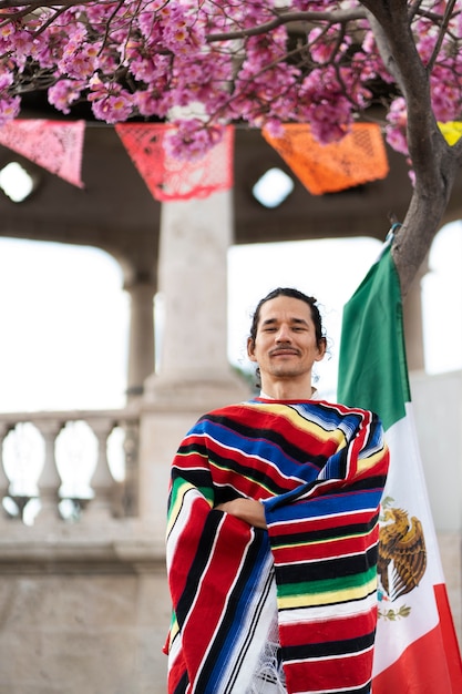 Proud man holding mexican flag medium shot