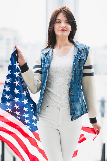 Proud woman walking with big USA flag