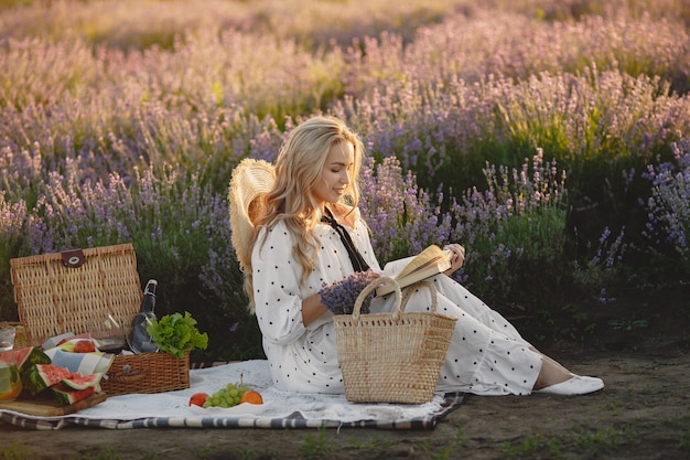 Free Photo provence woman relaxing in lavender field. lady in a picnic. woman with a straw hat.