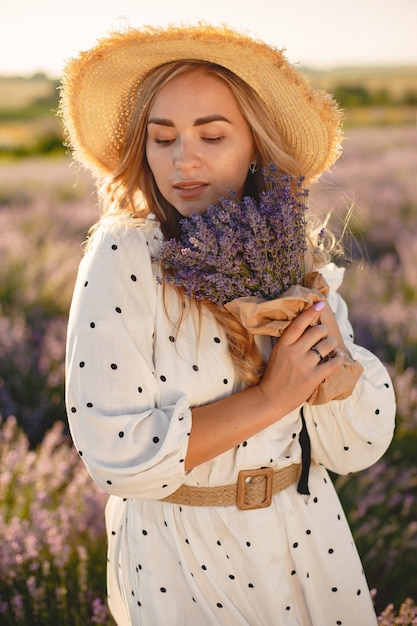 Free photo provence woman relaxing in lavender field. lady in a white dress. girl with bouquete of flowers.