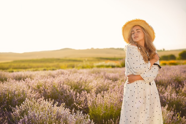 Provence woman relaxing in lavender field. Lady in a white dress. Girl with a straw hat.