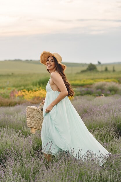 Provence woman relaxing in lavender field. Lady with a straw hat. Girl with bag.