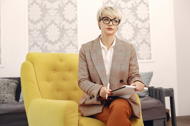 Free photo psychologist with glasses sitting on a chair at the office