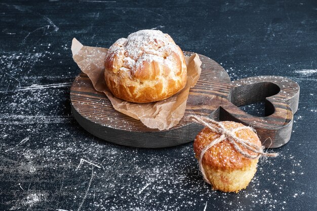 Puff pastry bun with cupcake on a wooden board. 