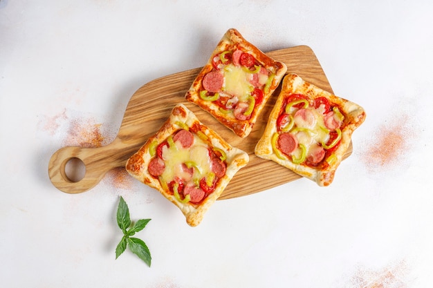 Puff pastry mini pizzas with sausages.