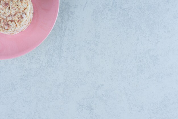 Puffed rice cakes and sweet cracker in the plate on marble.